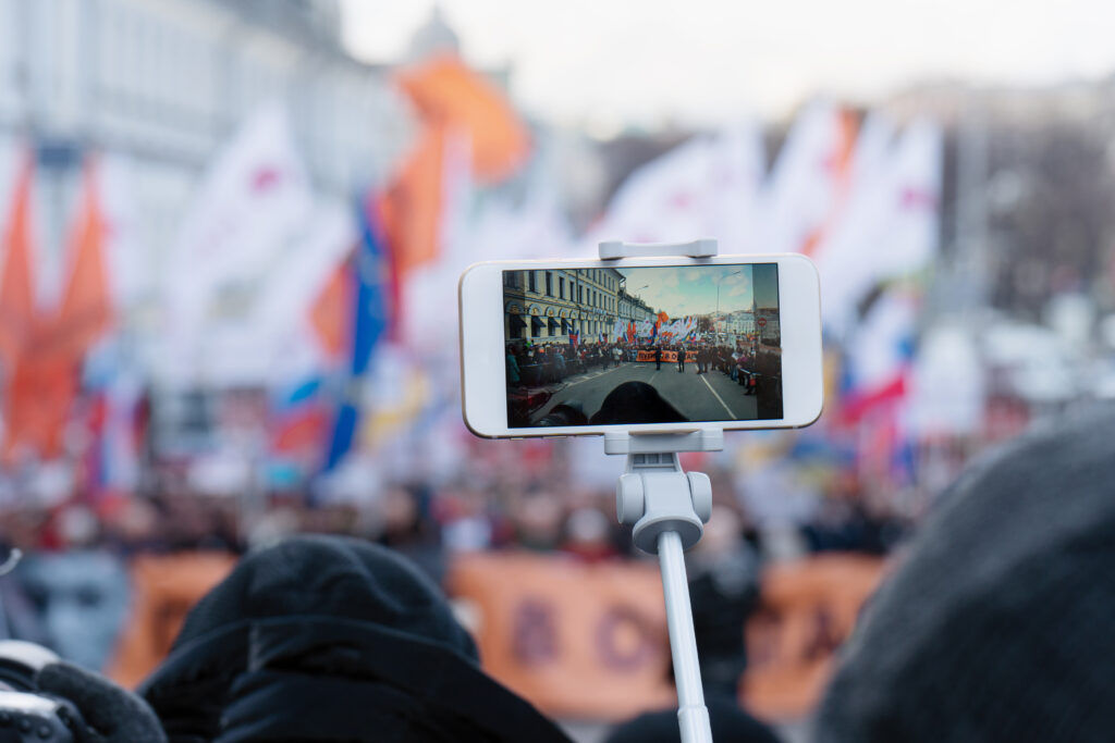 Blogger reporting using a smartphone during a political action in Moscow.
